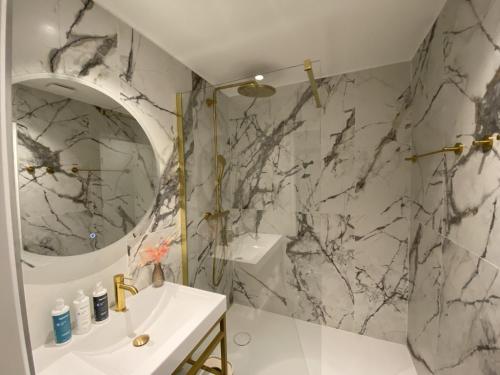 ein Badezimmer mit Waschbecken und Spiegel in der Unterkunft Best Western Plus Le Moderne in Caen