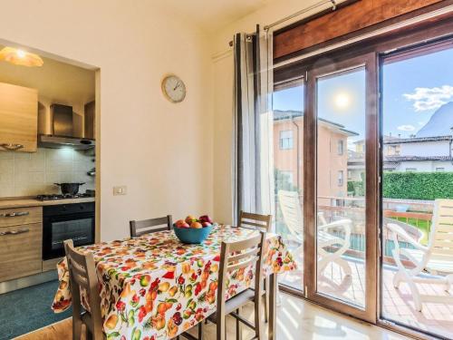 a kitchen and dining room with a table and a balcony at Apartment Casa Silvia by Interhome in Carlazzo
