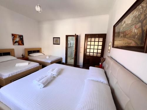 a hotel room with two beds and a mirror at ES Berat Apartments in Berat
