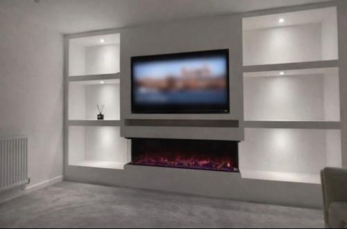a living room with a tv and a fireplace at Blackburn House for Professionals in Blackburn