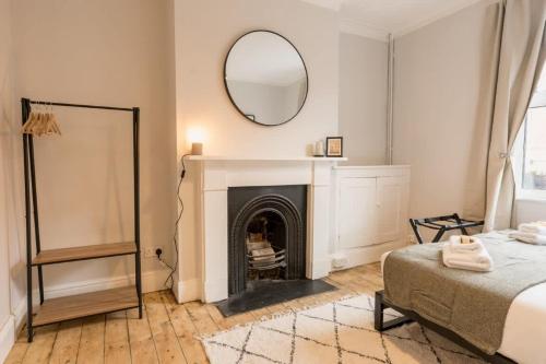 a bedroom with a fireplace and a mirror on the wall at Stylish 3 bed home in central Chester suburb in Chester