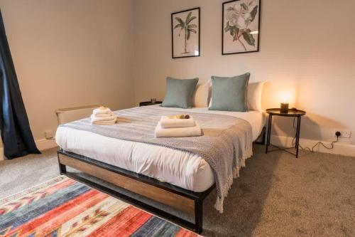 a bedroom with a large bed with towels on it at Stylish 3 bed home in central Chester suburb in Chester