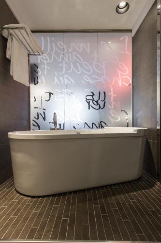 a bath tub in a bathroom with graffiti on the wall at Hotel Carlton in Bilbao