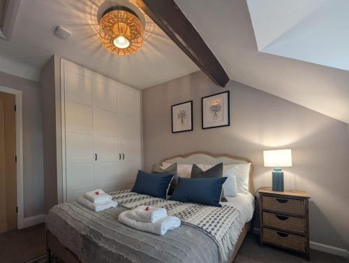 a bedroom with a bed with towels on it at Gem of a cottage Close to Chester Chester Zoo in Mickle Trafford