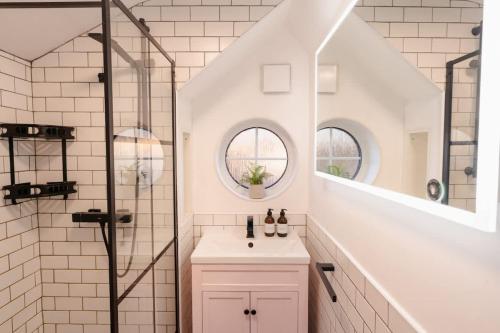a white bathroom with a sink and a shower at Gem of a cottage Close to Chester Chester Zoo in Mickle Trafford