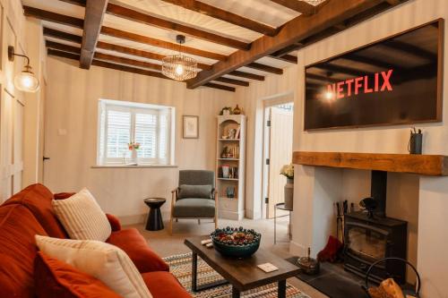 a living room with a fireplace and a tv at Gem of a cottage Close to Chester Chester Zoo in Mickle Trafford