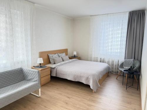 a bedroom with a bed and a chair and a window at Imantas apartment in Daugavpils