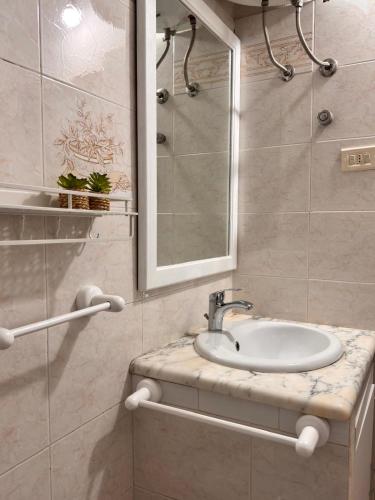 a bathroom with a sink and a mirror at Casa sul mare da Giovanna in La Caletta