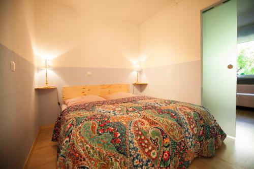 ローゼンハイムにあるFewo-Rosenheim im Zentrumのベッドルーム1室(カラフルなベッドカバー付)