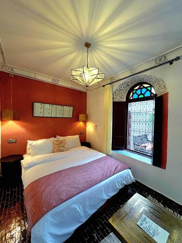 a bedroom with a large bed and a window at Riad Dar Mazaj Fes in Fez
