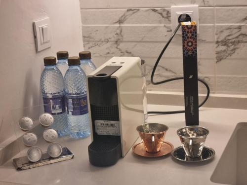 a counter top with bottles of water and a toaster at chez-moi sfax in Sfax