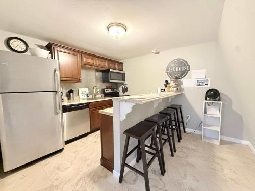 a kitchen with a refrigerator and a counter with stools at A Frame Escape Lake Access in Rocky Mount
