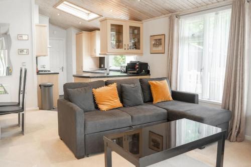 a living room with a couch and a table at Cosy Lodge on Farm with Donkeys Parking in Chester