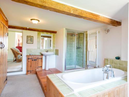 a bathroom with a tub and a shower and a sink at 4 Bed in Gillingham oc-80670 in West Stour