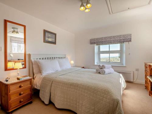 a bedroom with a bed with a teddy bear on it at 4 Bed in Swanage oc-76659 in Langton Matravers