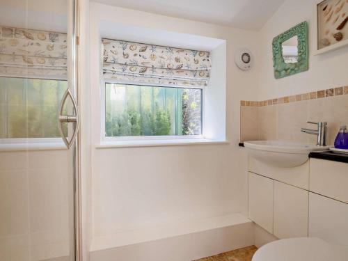 a bathroom with a shower and a toilet and a window at 4 Bed in Swanage oc-76659 in Langton Matravers
