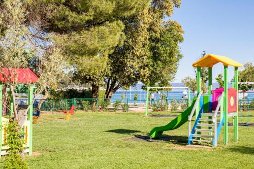 a playground with a slide in a park at MASLINICA Oliva Camping Pitches in Rabac