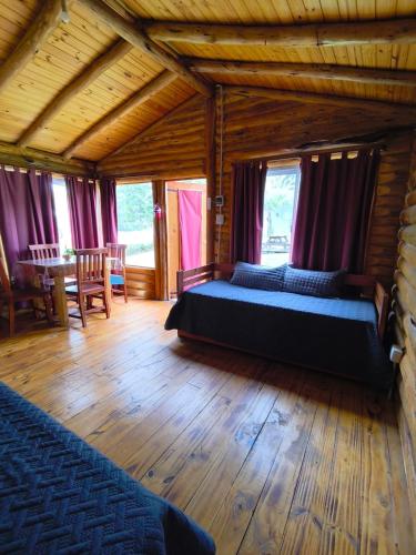 a bedroom with two beds and a wooden floor at Complejo majua in Cosquín