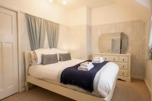 a bedroom with a bed with towels on it at Wirral Retreat Cosy Cottage Near Port Sunlight in Birkenhead
