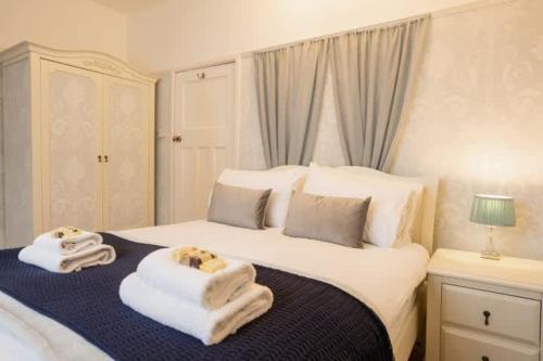 a bedroom with a bed with towels on it at Wirral Retreat Cosy Cottage Near Port Sunlight in Birkenhead