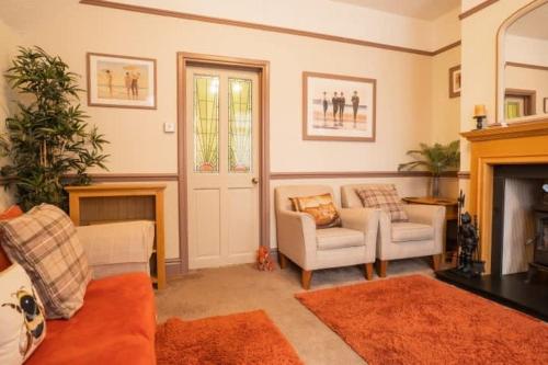 a living room with a couch and a fireplace at Wirral Retreat Cosy Cottage Near Port Sunlight in Birkenhead