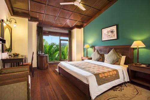 a bedroom with a large bed with a green wall at The Riverview Retreat Corbett by Leisure Hotels in Garjia