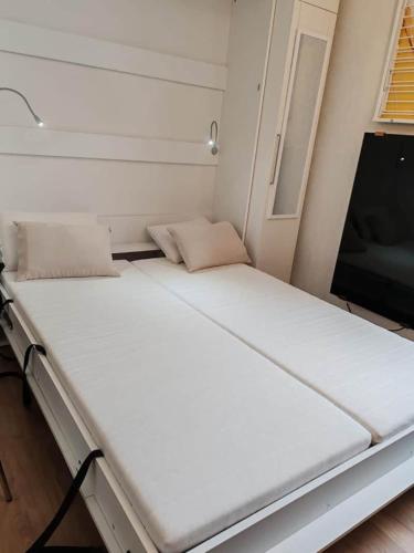 a large white bed in a room with a tv at Le 4 Saisons in Ustou