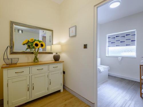 a bathroom with a vase of flowers on a dresser with a mirror at 2 Bed in Shanklin oc-78239 in Shanklin