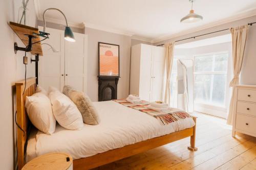 a bedroom with a bed with white sheets and a fireplace at Sleeps 6 off street parking close to city in Chester