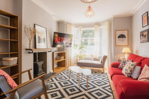 a living room with a red couch and a table at Sleeps 6 off street parking close to city in Chester