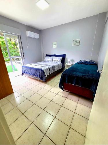 a bedroom with two beds and a window at Apto Completo Ar e Wi-Fi Parque Itaimbe in Santa Maria