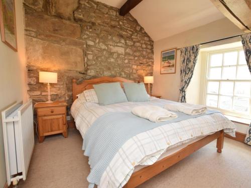 a bedroom with a bed and a stone wall at 4 Bed in Kettlewell oc-g0041 in Starbotton