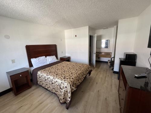 a hotel room with a bed and a television at Stallion Inn Motel in Long Beach