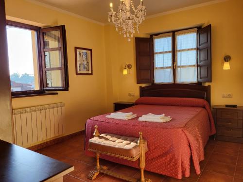 a bedroom with a bed with a red blanket and windows at Casa Pelayin in Cue
