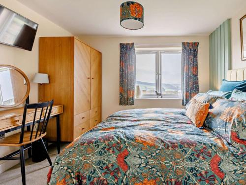 a bedroom with a bed and a desk and a window at 1 Bed in Sherborne oc-87292 in Lillington