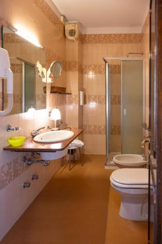 a bathroom with two sinks and a shower and a toilet at b&b casa pistacchio in Lovere