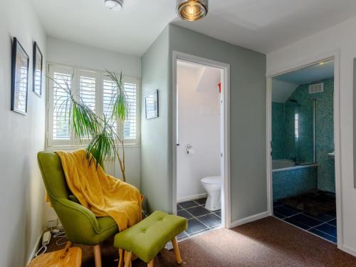 a bathroom with a green chair and a tub at 3 Bed in Wareham oc-78831 in Corfe Castle