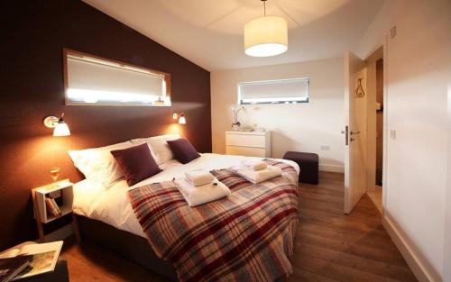 a bedroom with a large bed and two windows at Jog Lodge 2 By Together Travel - 3 Bed in John O Groats