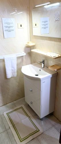 a bathroom with a white sink and towels at Villa Petrusa in Stromboli