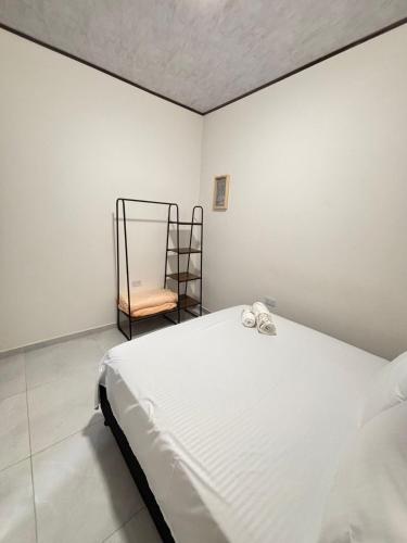 a bedroom with a white bed and a chair at Aparta Hotel La Osadía in Acacías