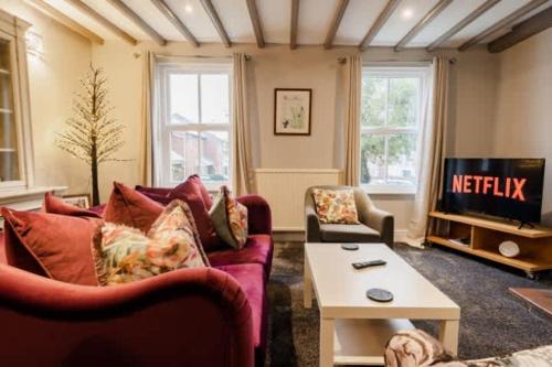 a living room with a red couch and a tv at Spacious City centre 2 bed home Parking Sleeps 4 in Chester