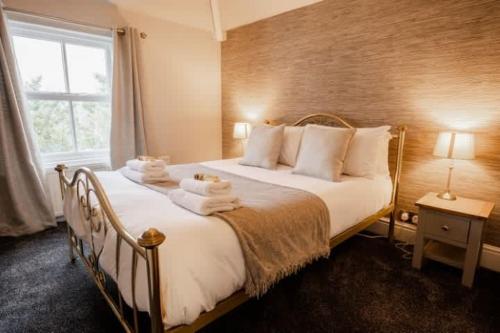 a bedroom with a large bed with towels on it at Spacious City centre 2 bed home Parking Sleeps 4 in Chester