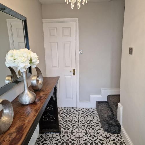 a hallway with a vase of flowers on a counter at Spacious City centre 2 bed home Parking Sleeps 4 in Chester