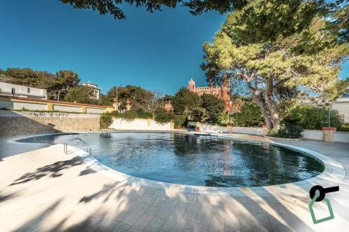 a swimming pool in a park with trees at Hotiday Leuca Porto in Leuca