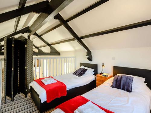 a bedroom with two beds with red and white sheets at 2 Bed in Fordingbridge oc-56823 in Woodgreen