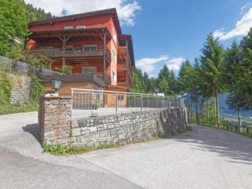 a house with a fence and a stone wall at Apartment Jacob by Interhome in Dölsach