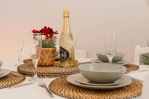 a table with a bottle of wine and plates and glasses at Stylish Chester Stay Free Parking Private Garden in Chester