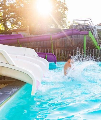 a man is in a water slide in a pool at Camping Lac aux Oiseaux - Mobil-home 3 Pièces 4 Personnes MAE-0991 in Martiel