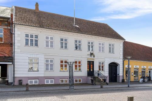 a large white building on the side of a street at Apotekergaarden in Stege