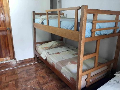 two bunk beds in a room with a wooden floor at Casa madrigueña rincón del mar in Rincón